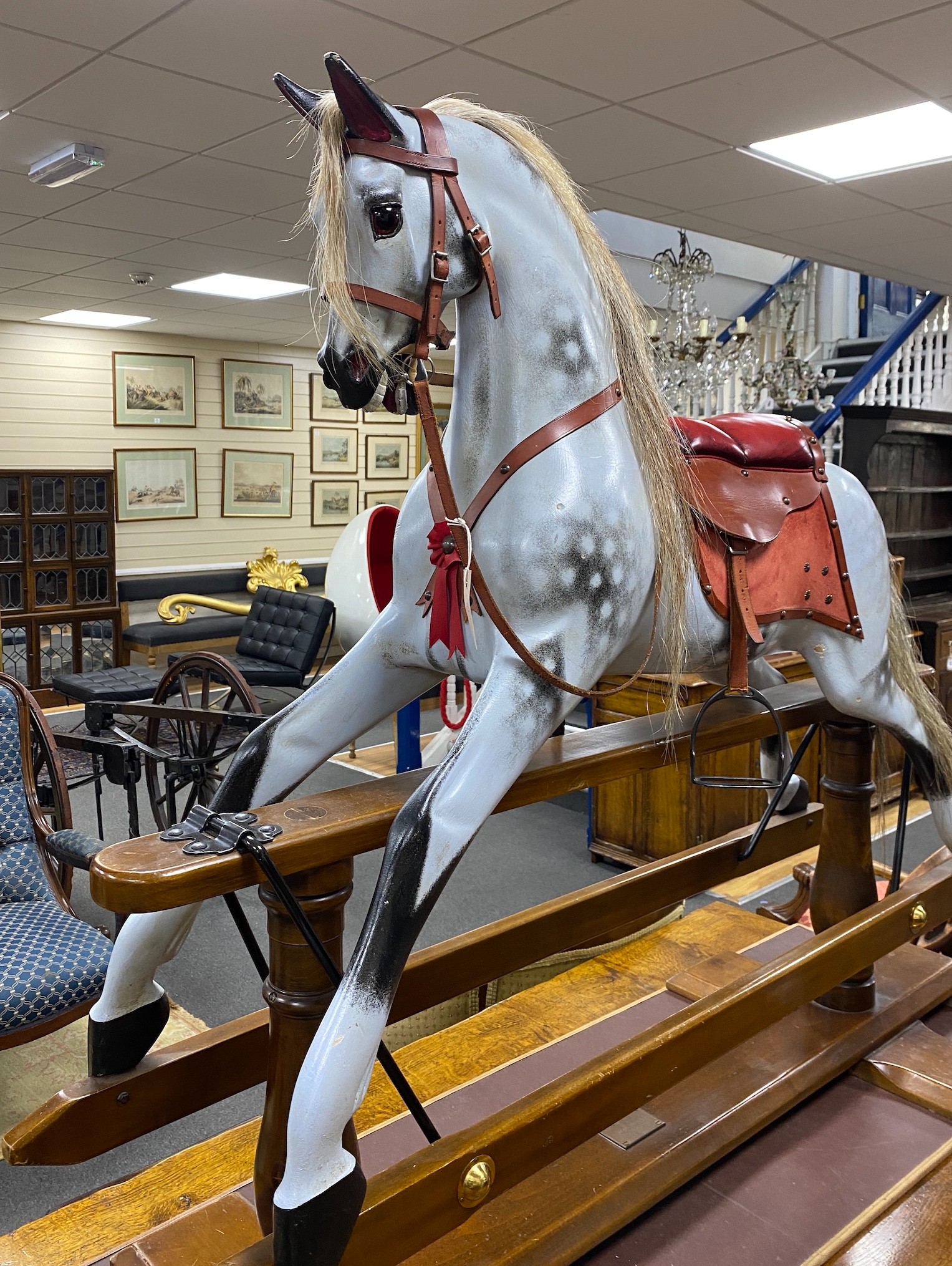 A Stevenson Brothers carved wood dapple grey rocking horse, with burgundy leather tack on beech safety frame, plaque dated 1997 and numbered 2872, length 152cm, height 120cm
